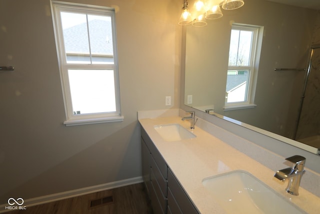 full bathroom with a sink, visible vents, baseboards, and double vanity