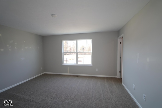 carpeted spare room with visible vents and baseboards