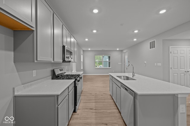 1721 Real St, Indianapolis, IN 46240 - kitchen with stainless steel appliances, a sink, gray cabinetry, light wood-style flooring, and recessed lighting
