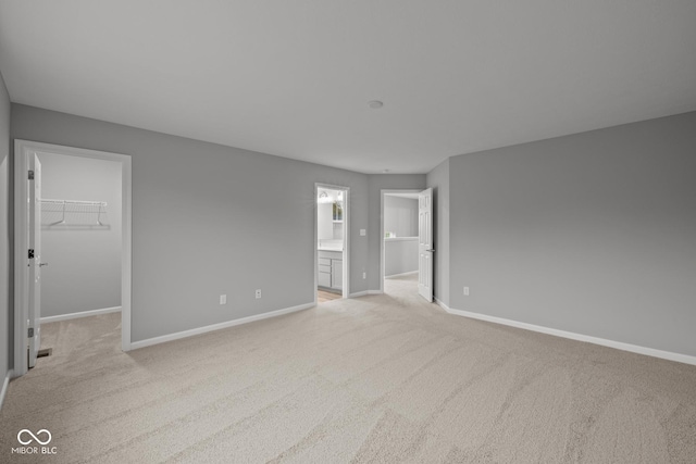 1721 Real St, Indianapolis, IN 46240 - unfurnished bedroom with a spacious closet, baseboards, and light carpet