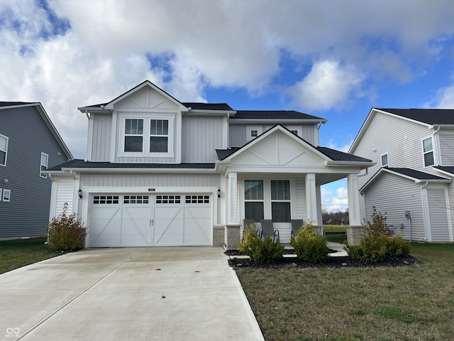 view of front of property featuring a front yard, a garage, and a porch