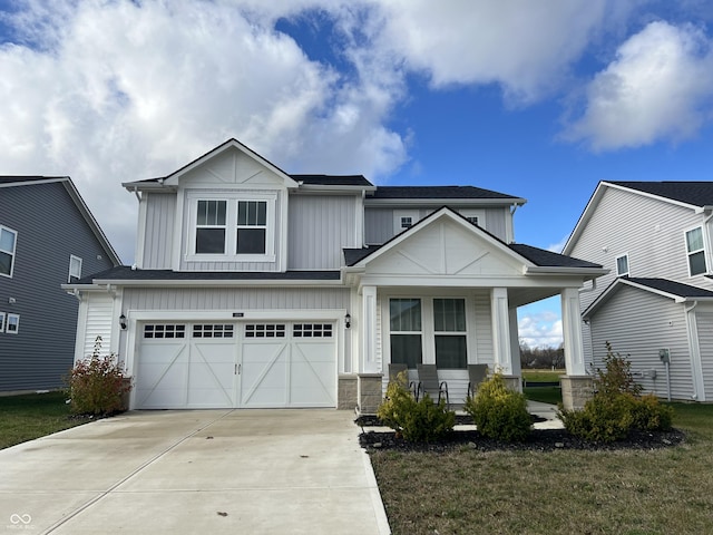 craftsman-style house featuring a front yard, covered porch, and a garage