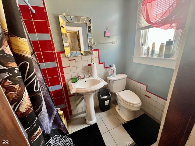 bathroom featuring toilet, walk in shower, tile patterned floors, and tile walls