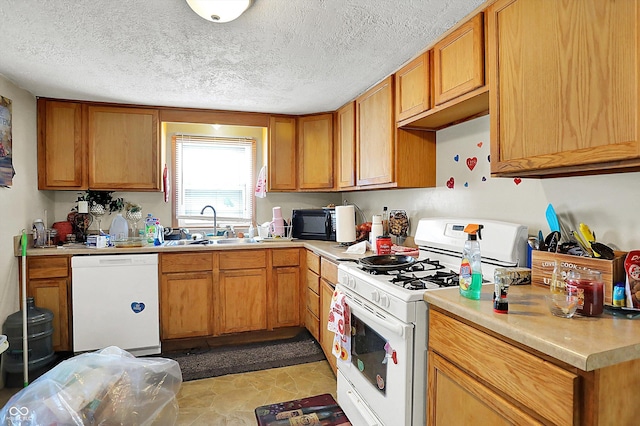 kitchen featuring a textured ceiling, sink, and white appliances