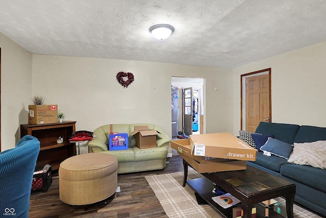 living room with dark wood-type flooring and a textured ceiling