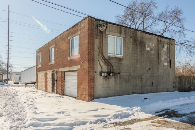 view of snowy exterior featuring a garage