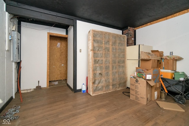 basement featuring electric panel and dark hardwood / wood-style flooring