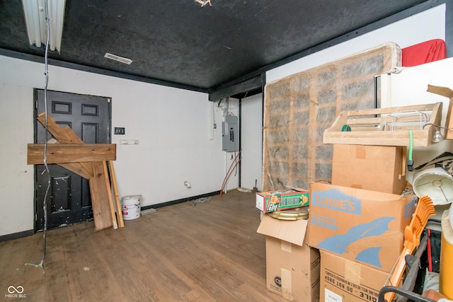 basement featuring hardwood / wood-style flooring and electric panel