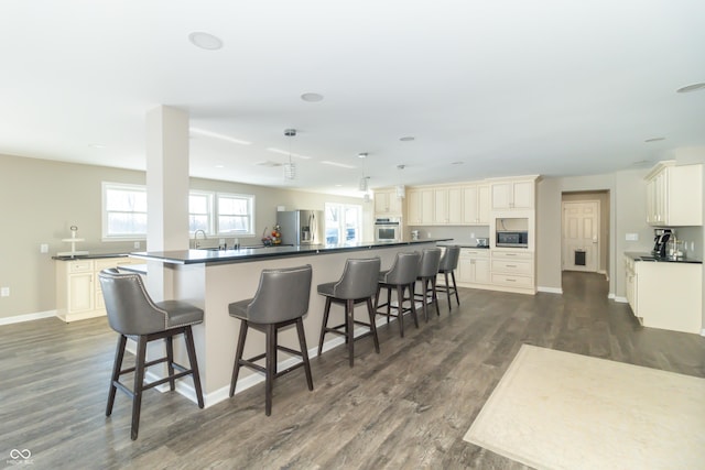 kitchen featuring a center island, dark hardwood / wood-style floors, a kitchen bar, and appliances with stainless steel finishes