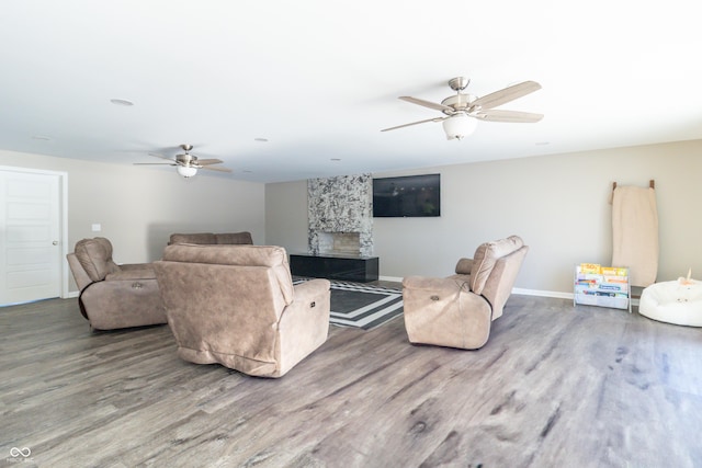 living room with a fireplace, hardwood / wood-style flooring, and ceiling fan