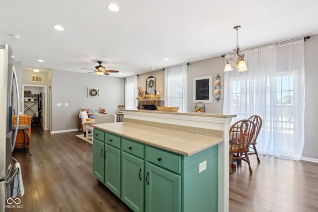 kitchen with hanging light fixtures, a kitchen island, a healthy amount of sunlight, and green cabinets