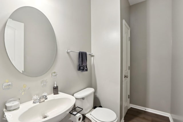 bathroom with sink, hardwood / wood-style floors, and toilet