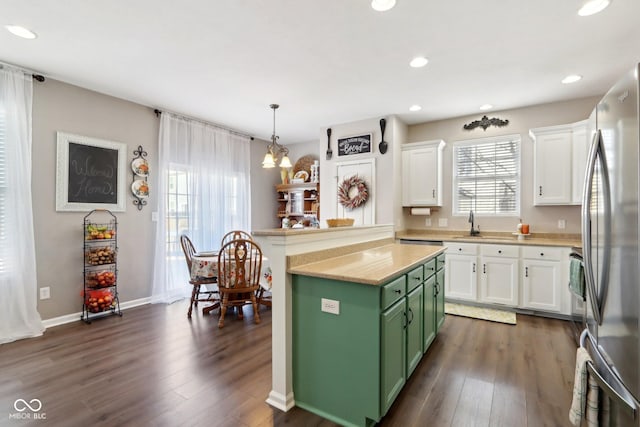 kitchen with green cabinetry, a center island, stainless steel refrigerator, pendant lighting, and white cabinets