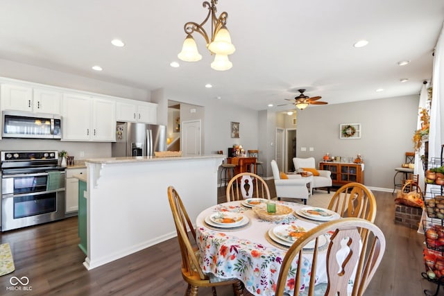 dining space with dark hardwood / wood-style floors and ceiling fan with notable chandelier