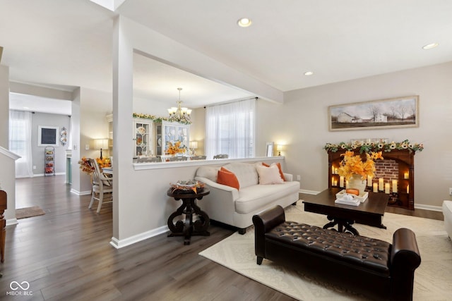 living room with an inviting chandelier, hardwood / wood-style floors, and beamed ceiling