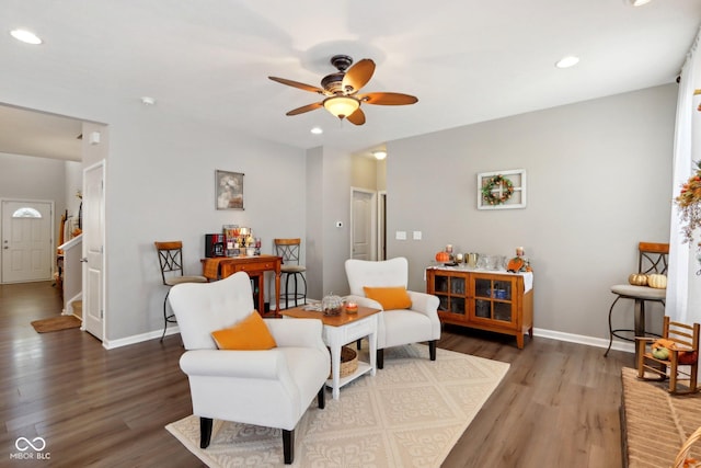 sitting room with dark wood-type flooring and ceiling fan