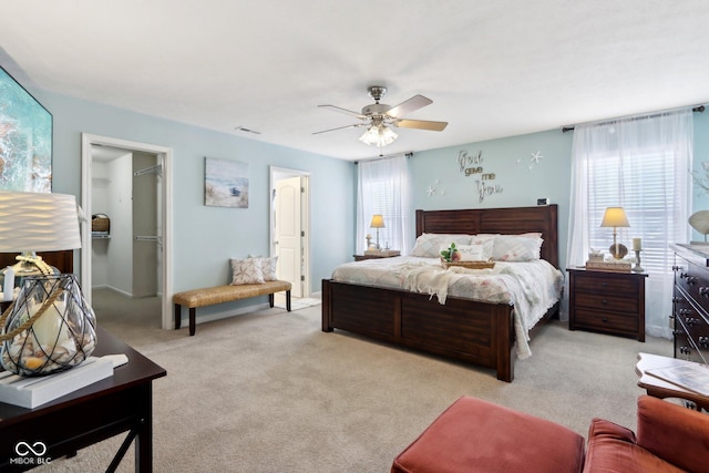 carpeted bedroom with ceiling fan, a spacious closet, and a closet