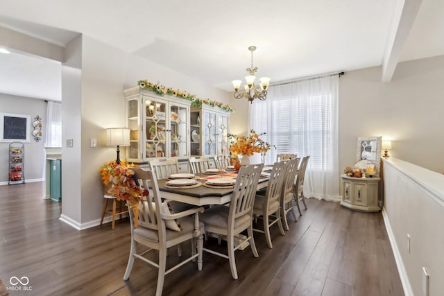 dining area with dark hardwood / wood-style floors and a notable chandelier