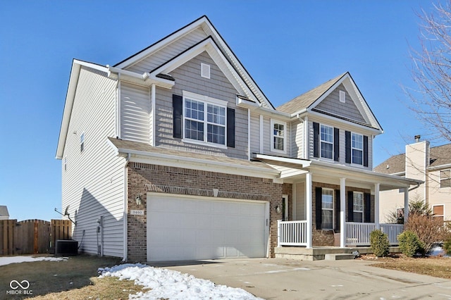 view of front of property featuring a garage, central AC unit, and covered porch