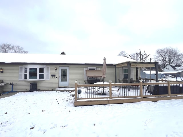 snow covered house featuring a deck