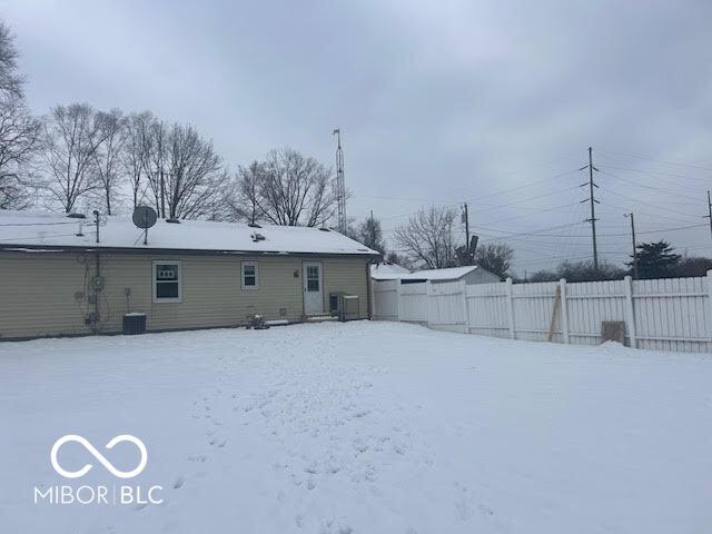 snow covered house with central AC unit