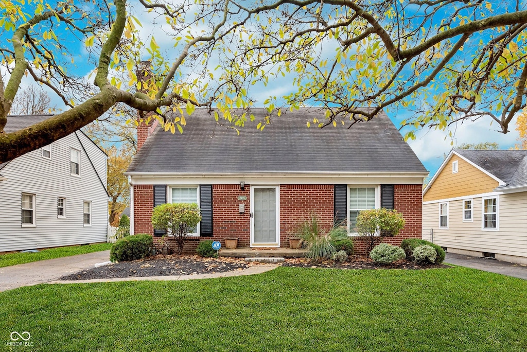 cape cod-style house with a front lawn