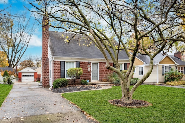 view of front of house with a front yard, a garage, and an outdoor structure