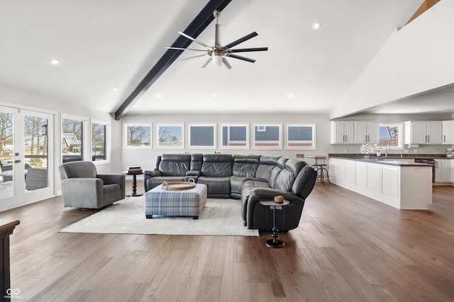 living room featuring french doors, light hardwood / wood-style floors, ceiling fan, high vaulted ceiling, and beam ceiling