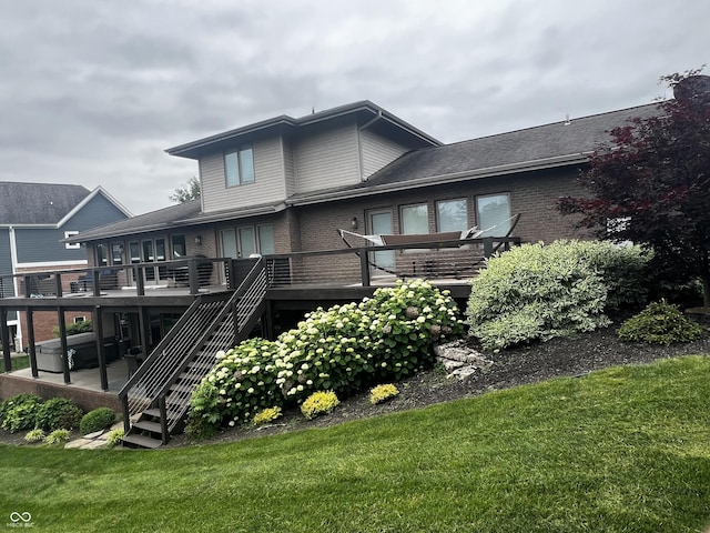 rear view of property featuring stairs, brick siding, a lawn, and a wooden deck