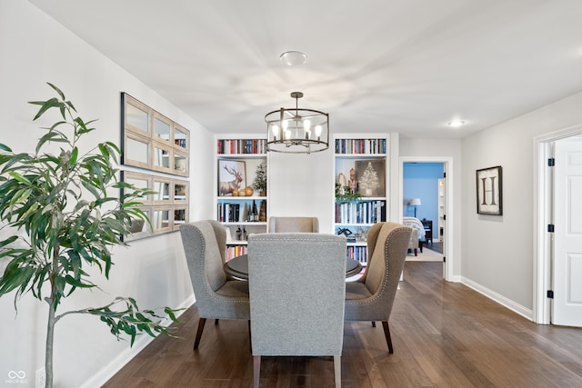 dining area with built in shelves, dark hardwood / wood-style flooring, and a notable chandelier