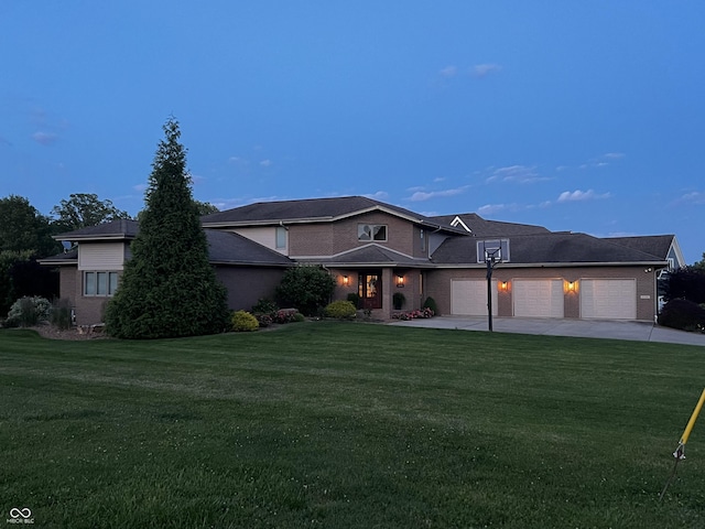 view of front of home with a garage, a front yard, concrete driveway, and brick siding