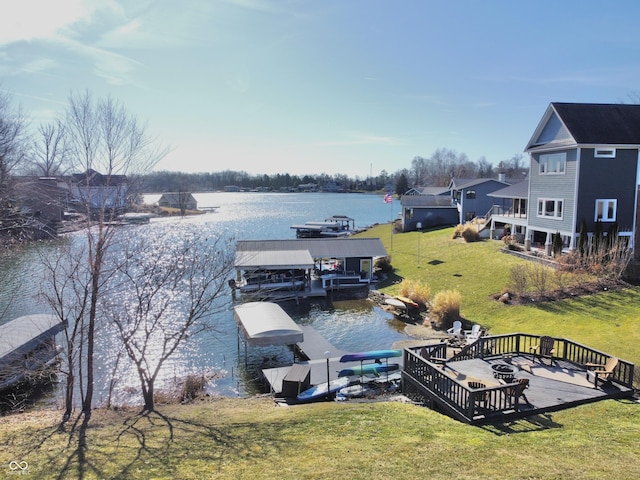 dock area with a yard and a deck with water view