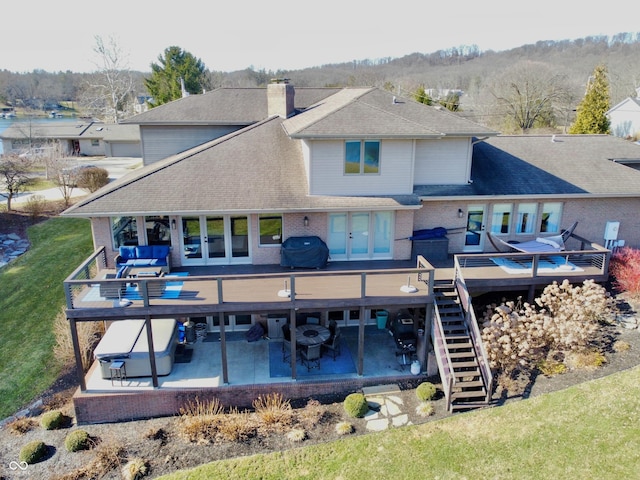 rear view of house with french doors, outdoor dining area, and a wooden deck