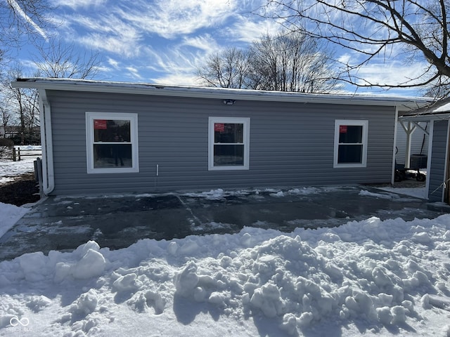 view of snow covered exterior with central AC