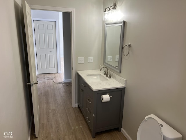 bathroom with vanity, toilet, and wood-type flooring