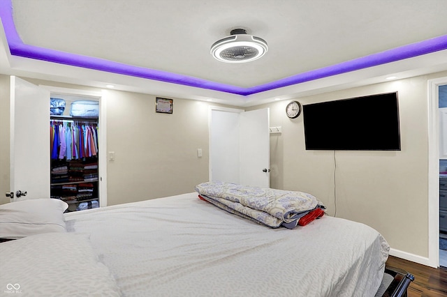 bedroom featuring dark hardwood / wood-style floors, a closet, and a raised ceiling