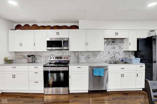 kitchen featuring sink, backsplash, white cabinets, and stainless steel appliances