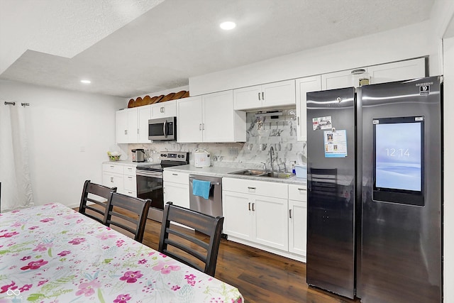 kitchen with tasteful backsplash, white cabinets, sink, and stainless steel appliances