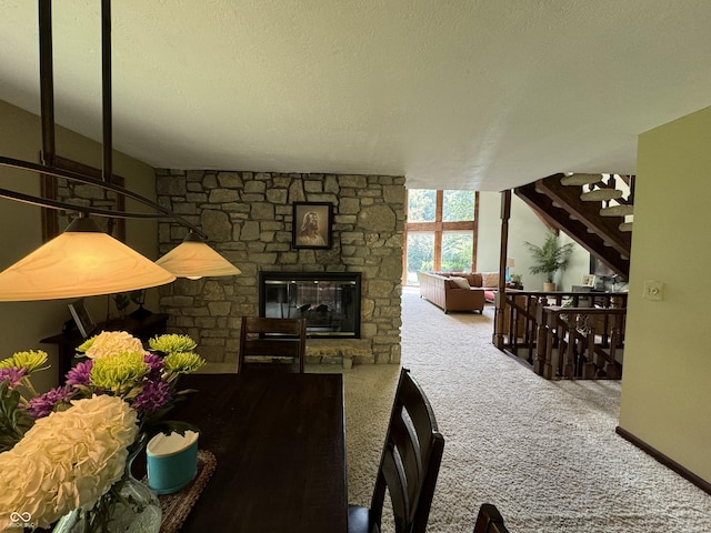 carpeted dining space featuring a textured ceiling and a stone fireplace