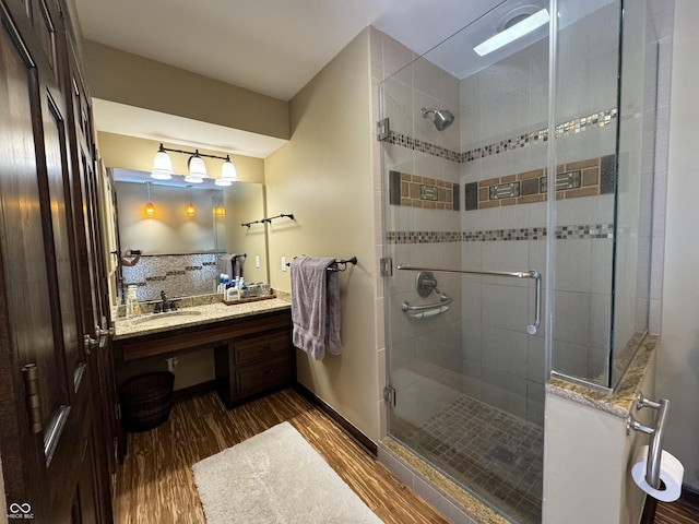 bathroom with hardwood / wood-style floors, an enclosed shower, and vanity