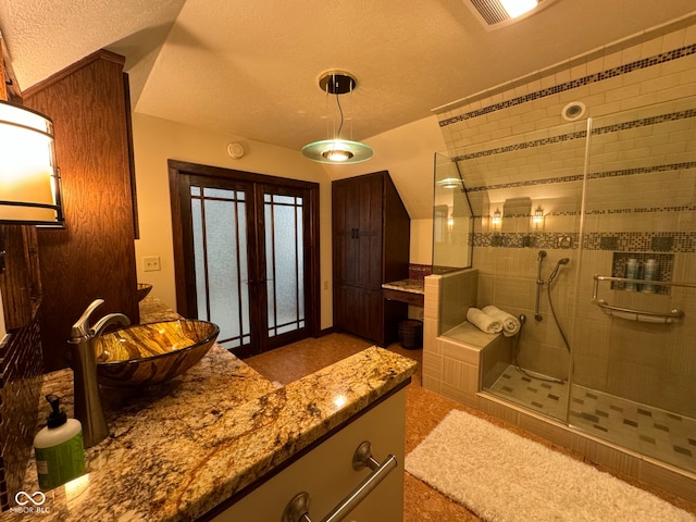 bathroom with a shower with door, french doors, a textured ceiling, and vanity