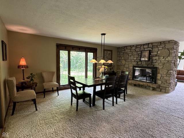 carpeted dining space with a fireplace and a textured ceiling