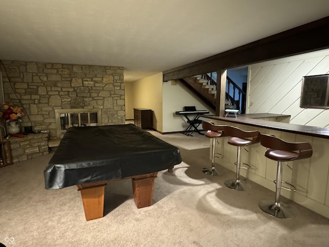 rec room with pool table, a stone fireplace, and carpet flooring