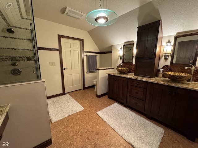 bathroom featuring lofted ceiling, an enclosed shower, vanity, and toilet