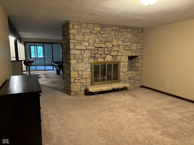 living room with a textured ceiling, a stone fireplace, and carpet floors