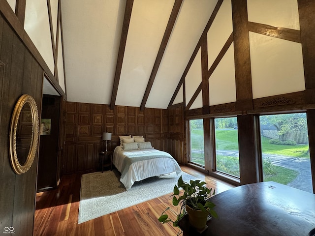 bedroom featuring high vaulted ceiling, wooden walls, and dark hardwood / wood-style flooring