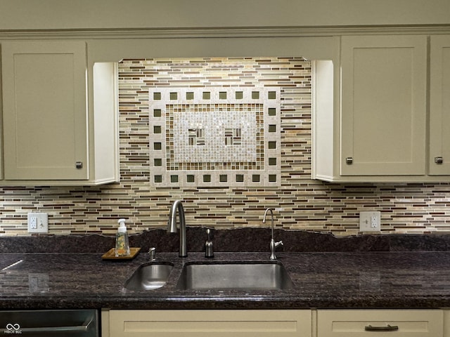 kitchen featuring sink, white cabinets, dark stone countertops, and tasteful backsplash