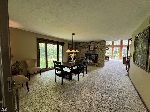 carpeted dining room featuring a textured ceiling and a stone fireplace