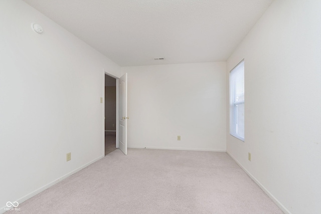 unfurnished room featuring light carpet