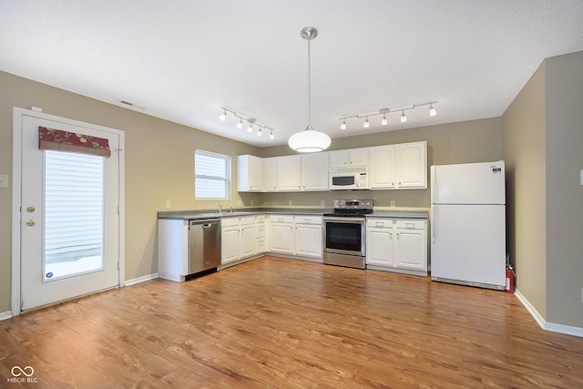 kitchen featuring white cabinetry, appliances with stainless steel finishes, light hardwood / wood-style flooring, and a healthy amount of sunlight